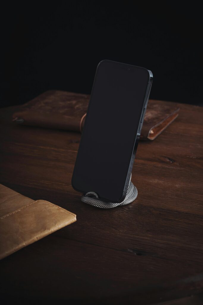 Telefon na drewnianym stole – symbol kontaktu z firmą windykacyjną i formalnej komunikacji